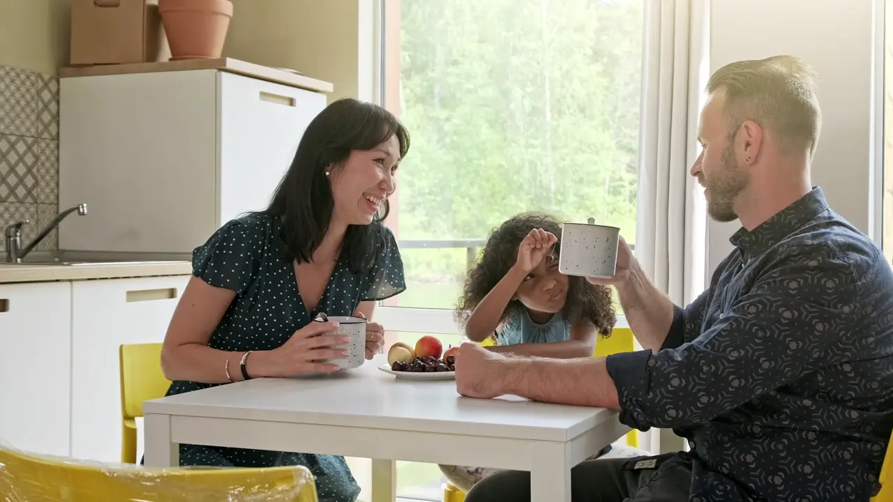 Family laughing together at the kitchen table
